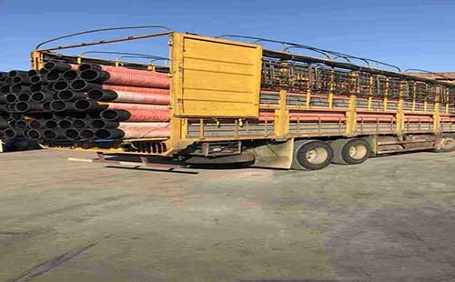 truck loaded with large rubber suction hoses for transport