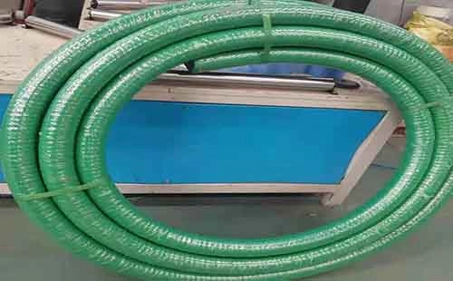 green flexible chemical hose coiled and secured with straps