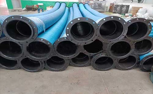 stacked blue industrial suction hoses with black flanges